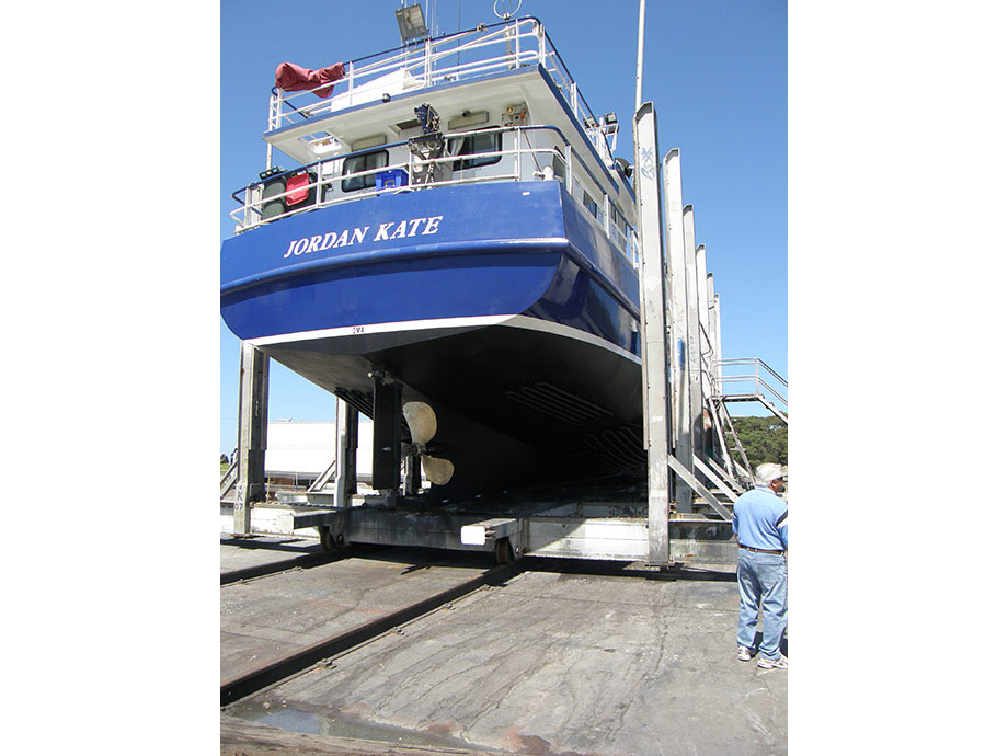 Stern view of vessel on slip with antifoul, boot line and blue painted to underside of sponson. Vessel at Ulladulla.