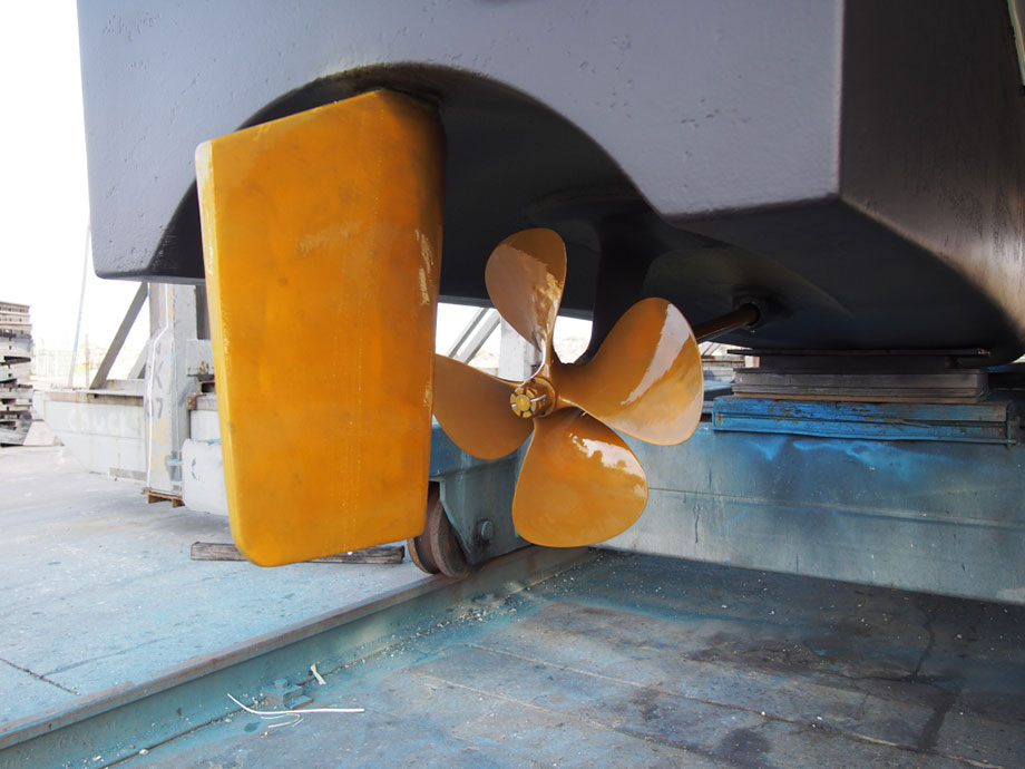 Closeup view of rudder and prop on recreational power cat. Prop and rudder painted with prop speed.
