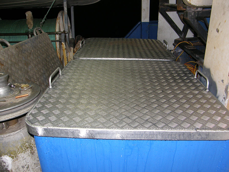 Commercial fishing vessel, brine tank lids showing condensation as refrigeration system operating.